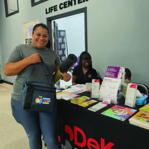 Community member picking up some freebies while getting health education